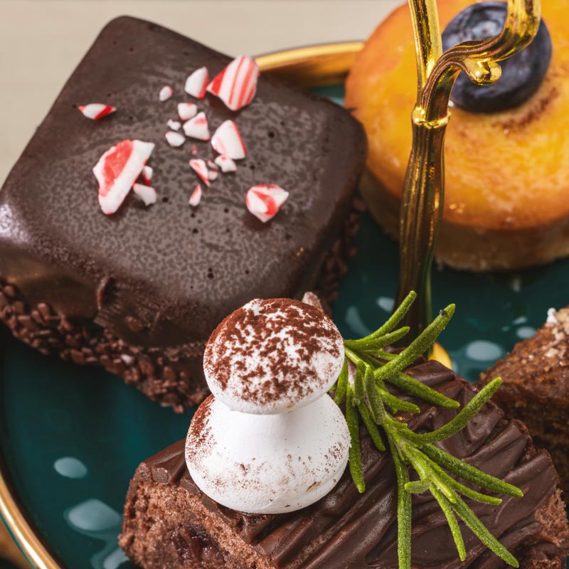 Chocolate desserts with white cream and green leaves on a plate