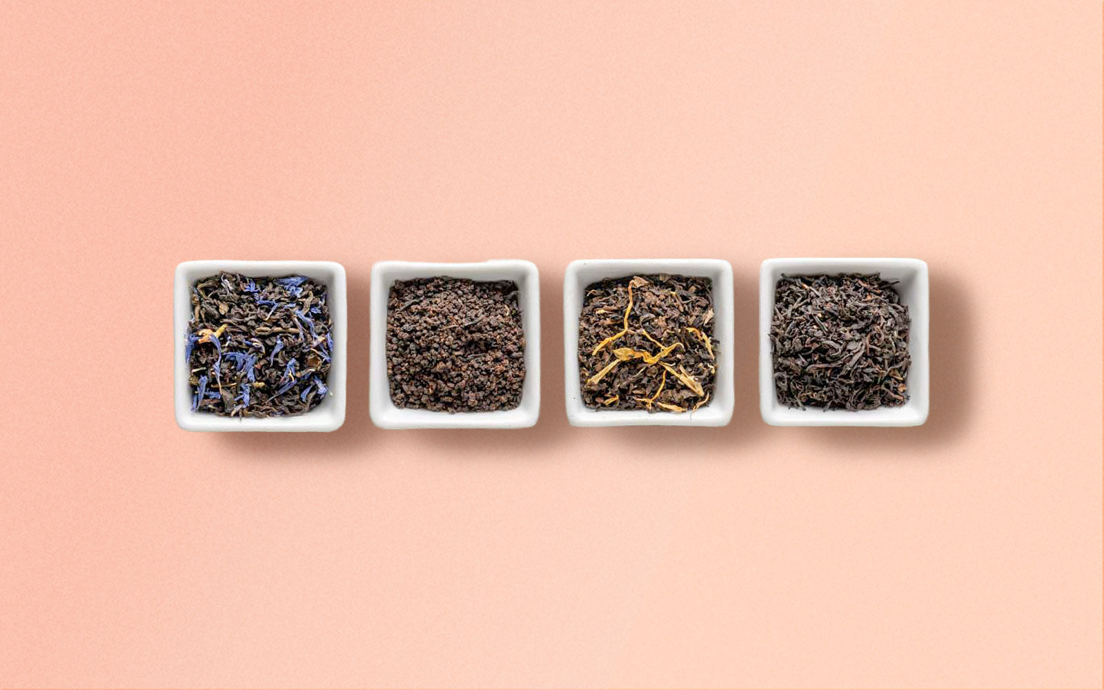 Four small white containers with Black Tea