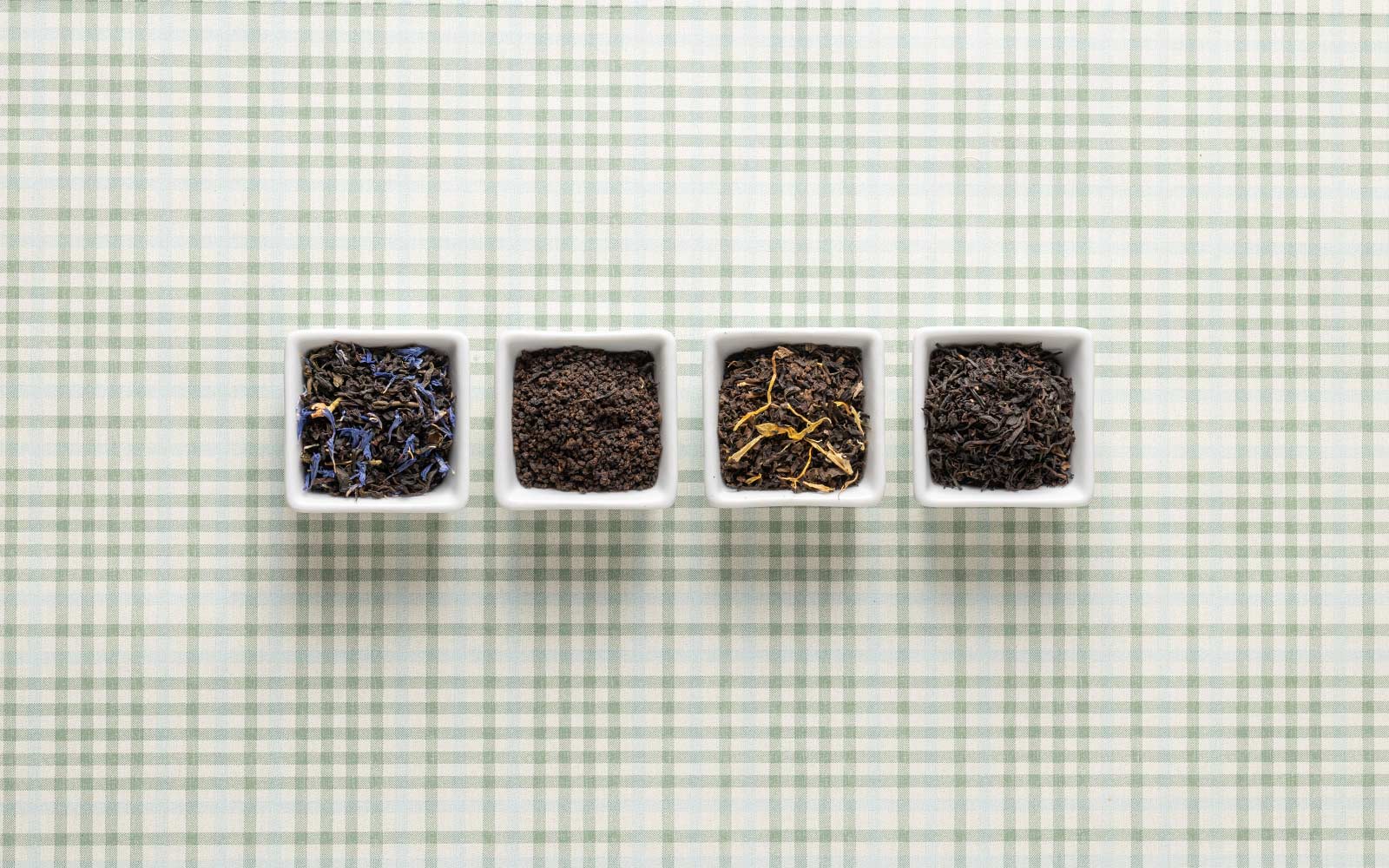 Black Tea in small containers showing the full leaf texture.