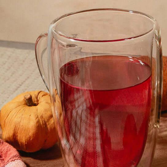 Cup of tea on a wood board with pumpkins and tea tin