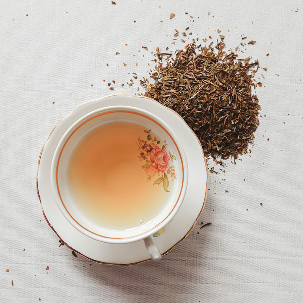 Brewed White Tea with Loose leaf next to the cup